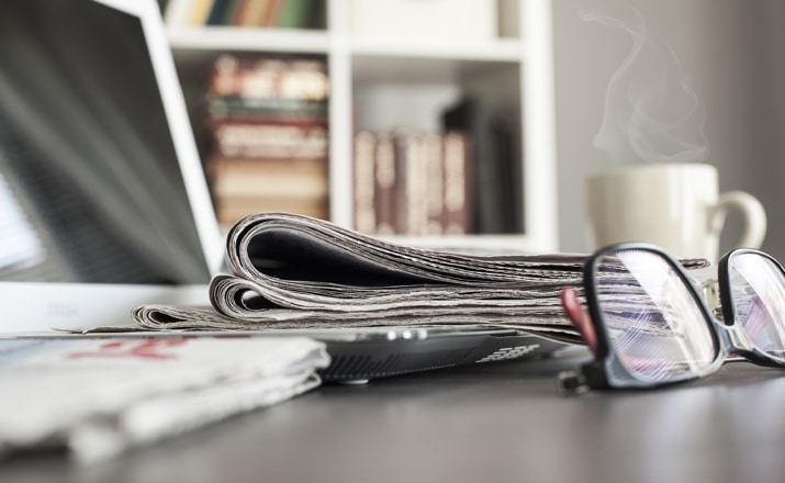 Glasses next to a newspaper